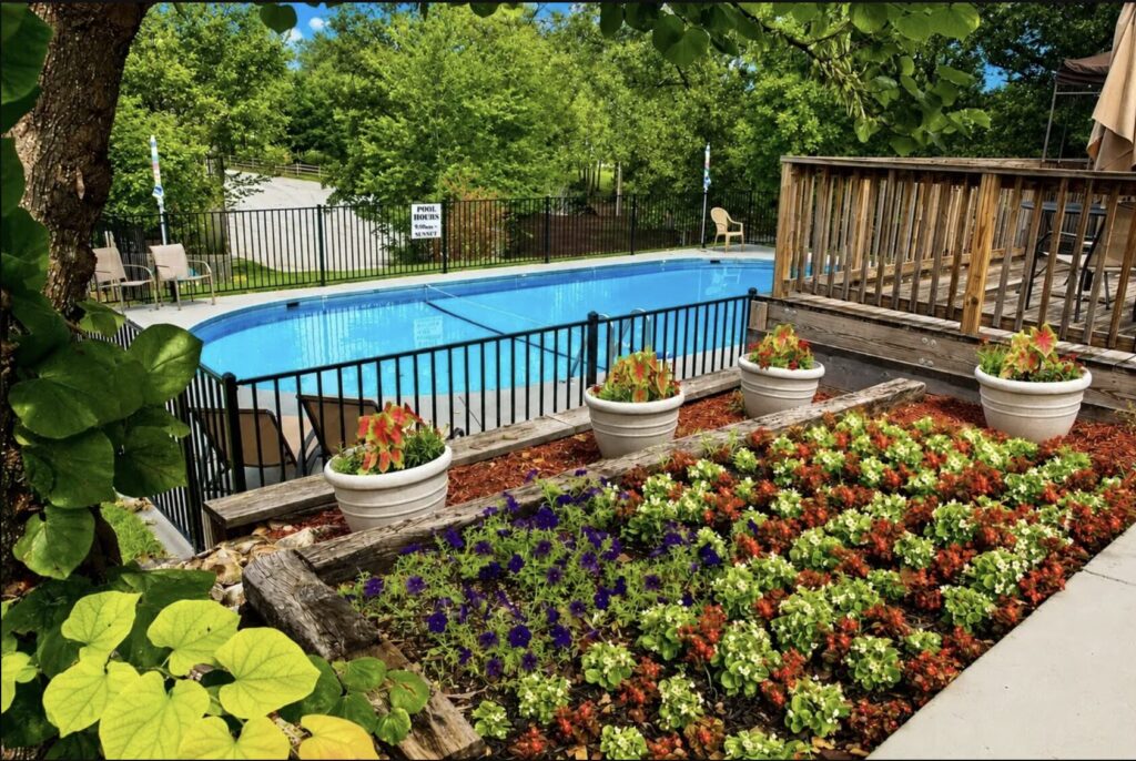 Side view of the pool at Unhitched Branson RV Park with garden vegetation and plants in Branson, Missouri